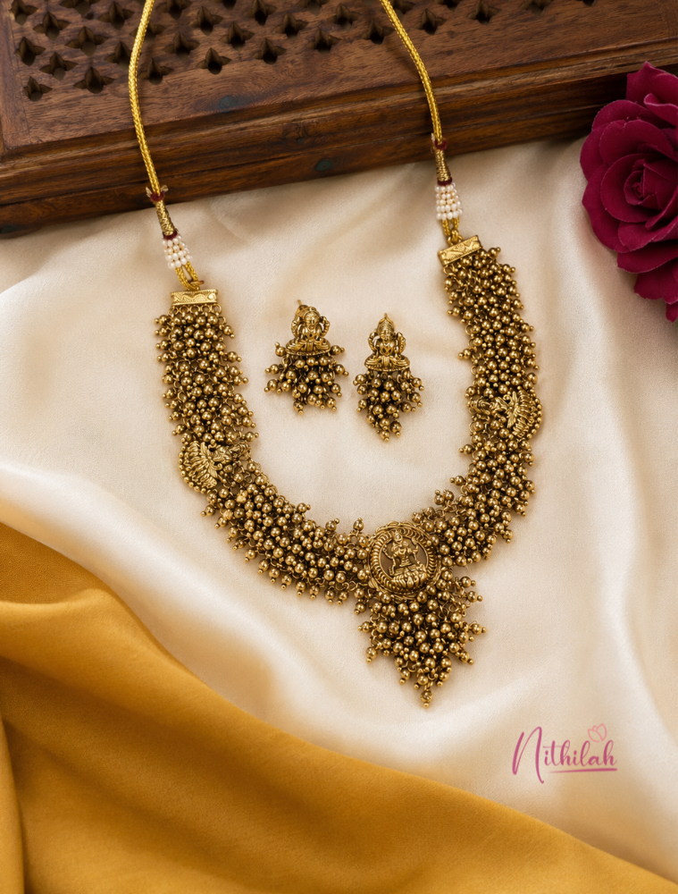Antique Gold Lakshmi Temple Choker Necklace Set with traditional ball detailing and matching Temple earrings displayed on silk fabric.