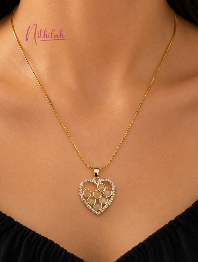 Woman wearing an anti-tarnish gold heart pendant necklace with elegant crystal detailing.