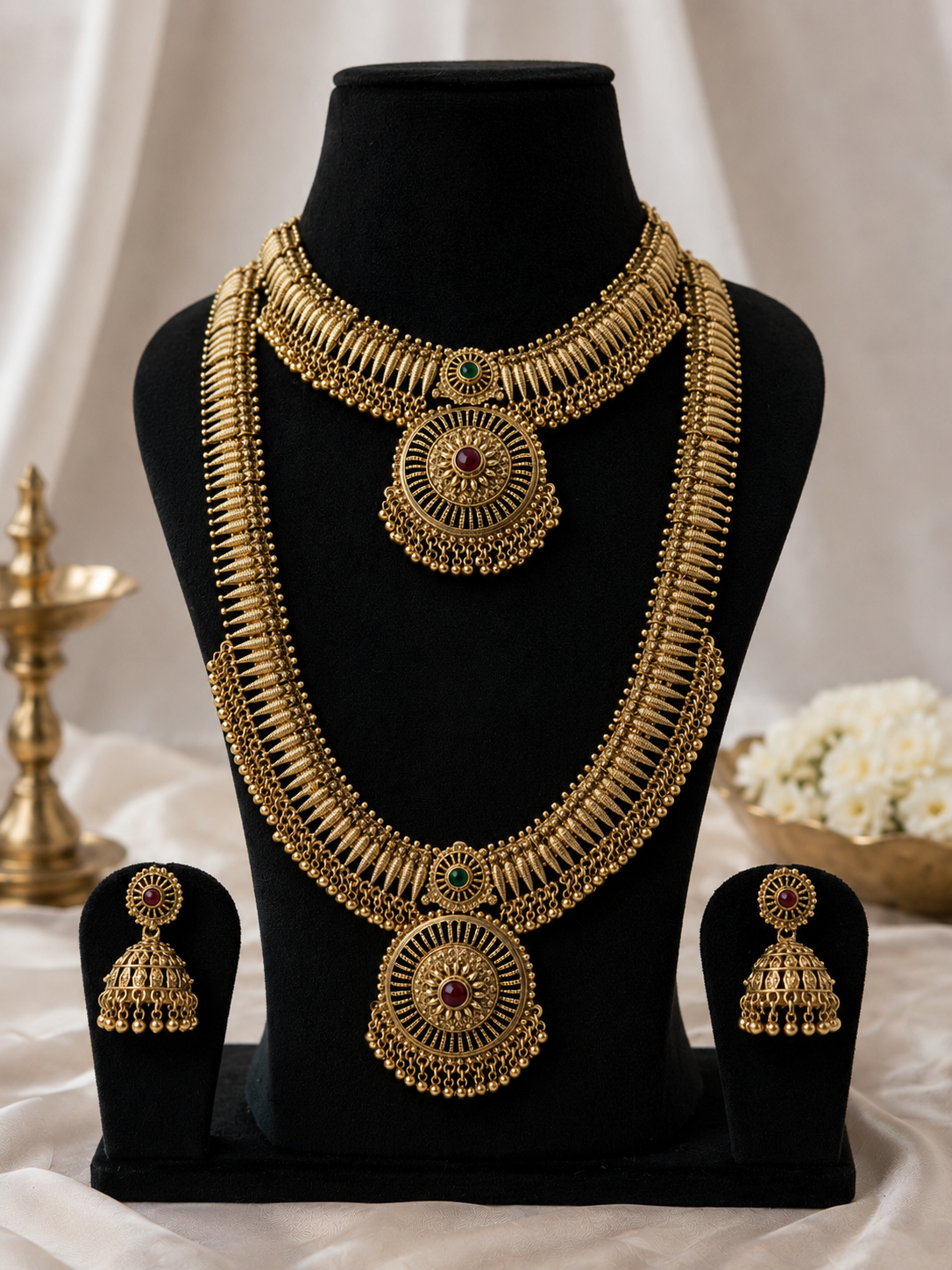 Antique Gold Finish Traditional Short & Long Necklace Set with matching Jhumka Earrings featuring intricate handcrafted antique detailing for weddings, festivals and ethnic wear.