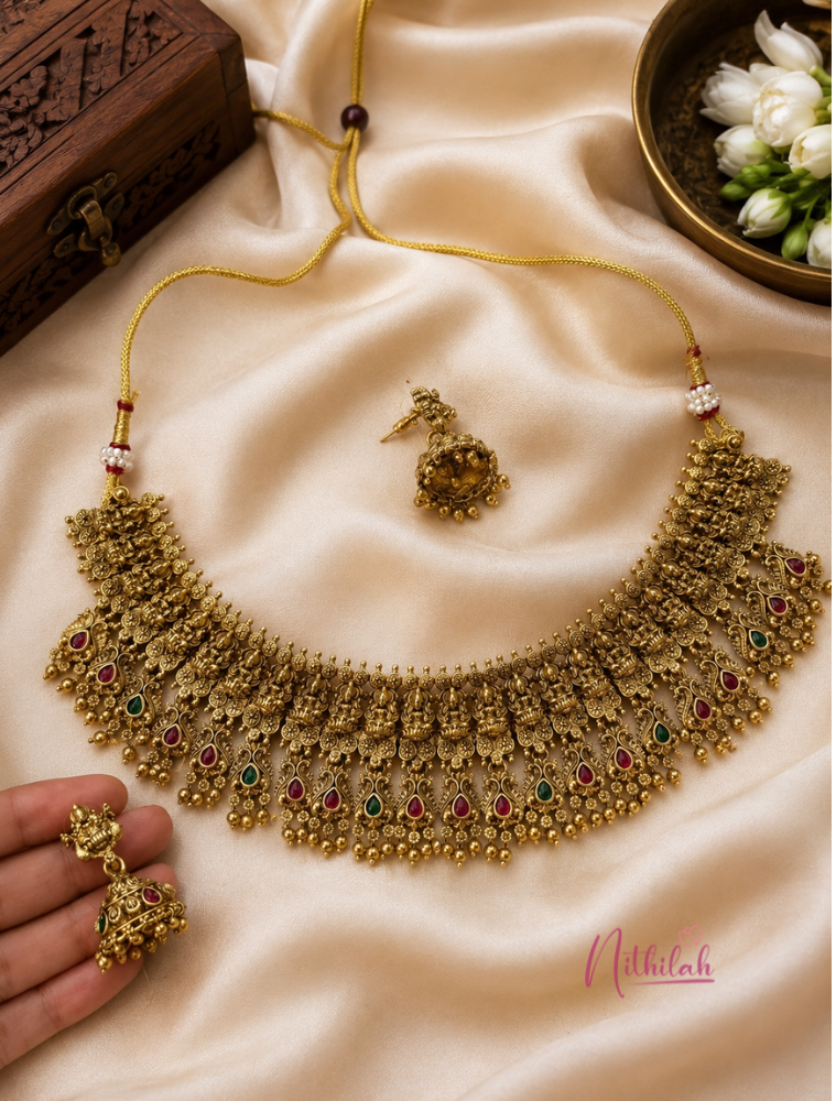 Antique Gold Finish Lakshmi Temple Choker Necklace Set with Matching Jhumka Earrings displayed in a premium flat lay arrangement