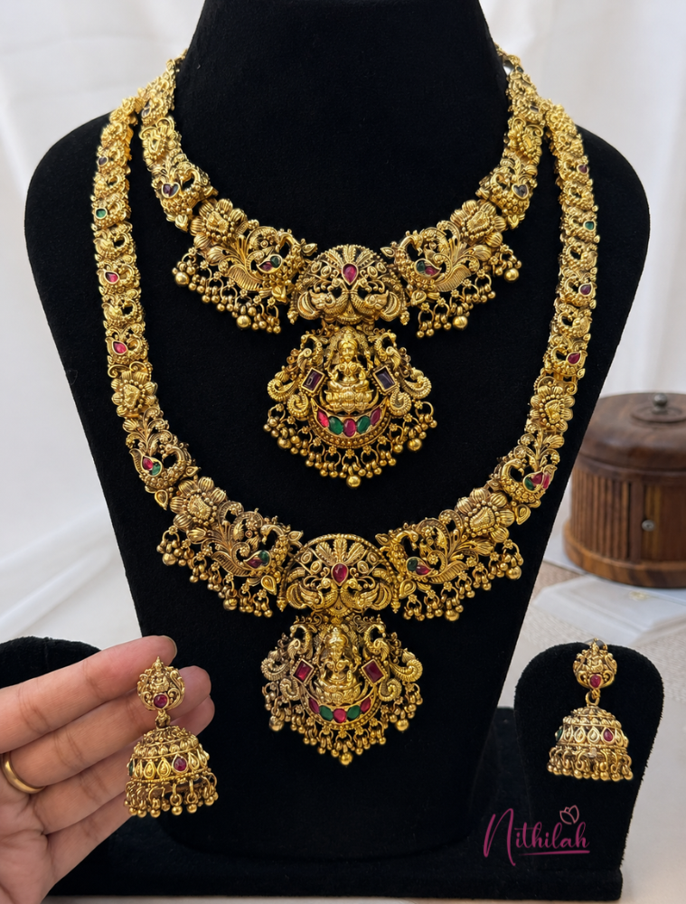 Antique Gold Finish Lakshmi Temple Short Necklace and Long Haram Set with Matching Lakshmi Jhumka Earrings displayed on a black velvet jewellery bust.
