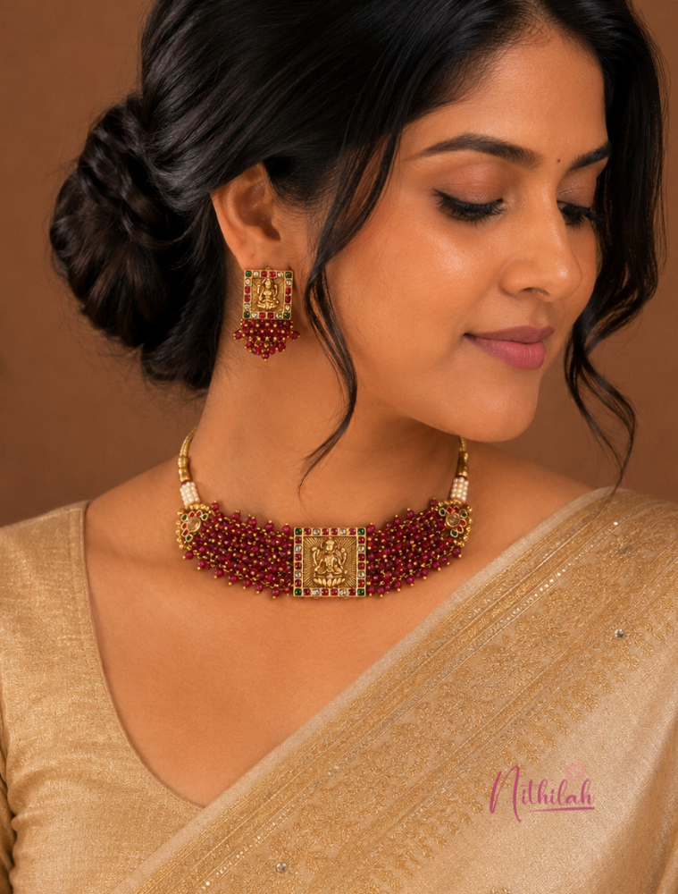 South Indian model wearing an Antique Gold Lakshmi Temple Choker Necklace Set with ruby bead detailing and matching Temple earrings.