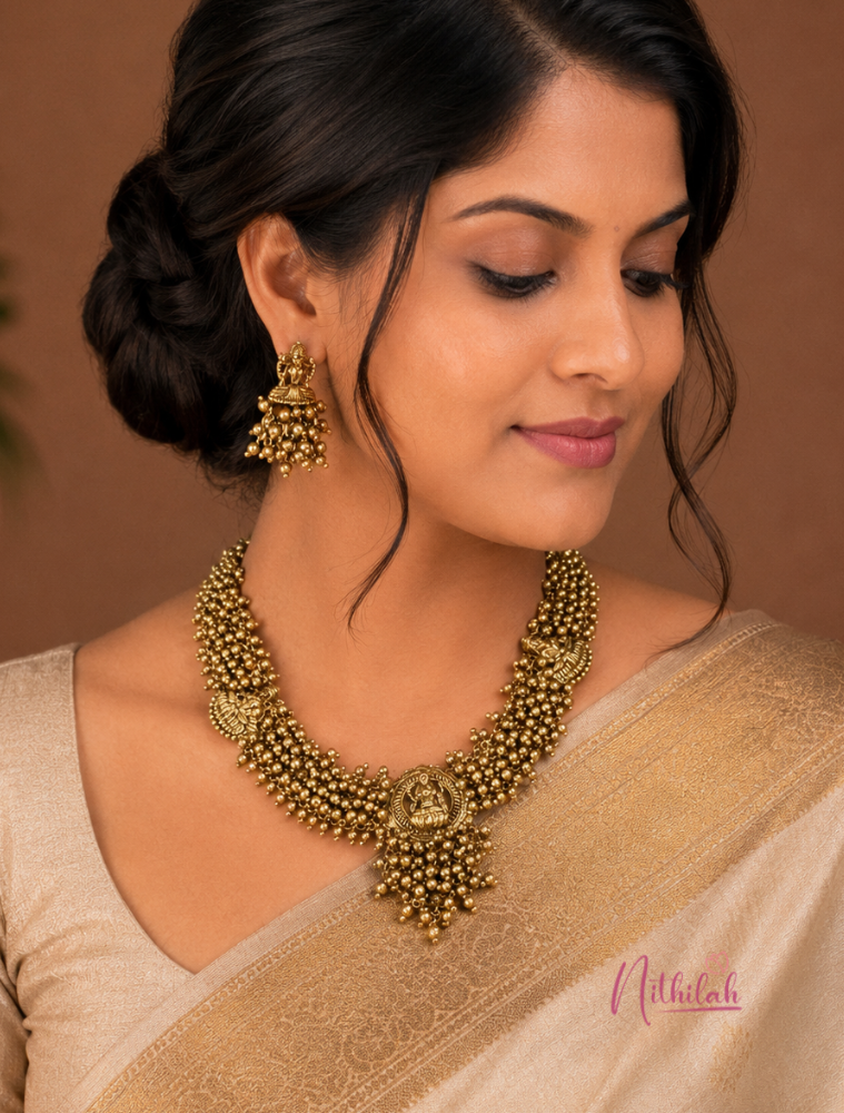 South Indian model wearing an Antique Gold Lakshmi Temple Choker Necklace Set with Lakshmi pendant and matching Temple earrings.