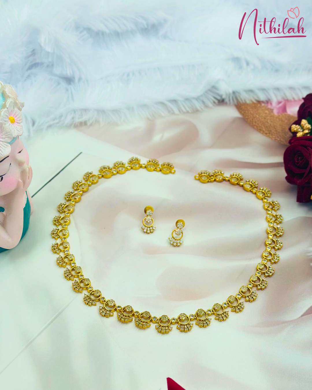 Angled view of a gold-finish CZ floral necklace set with matching earrings