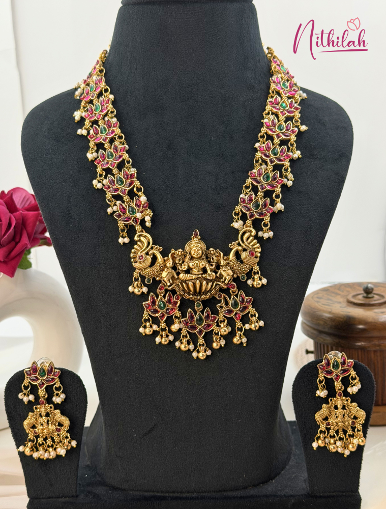 Gold necklace with colorful stones on a black mannequin, Nithilah brand visible