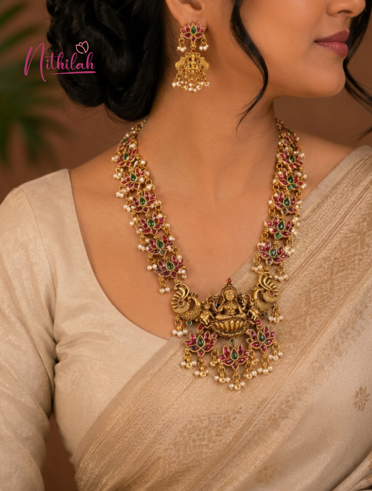Close-up of a woman wearing an ornate gold necklace and earrings, with 'Nithilah' branding.