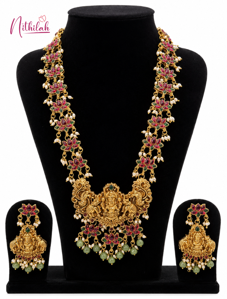 Gold necklace with pink and green stones on a black mannequin with matching earrings.