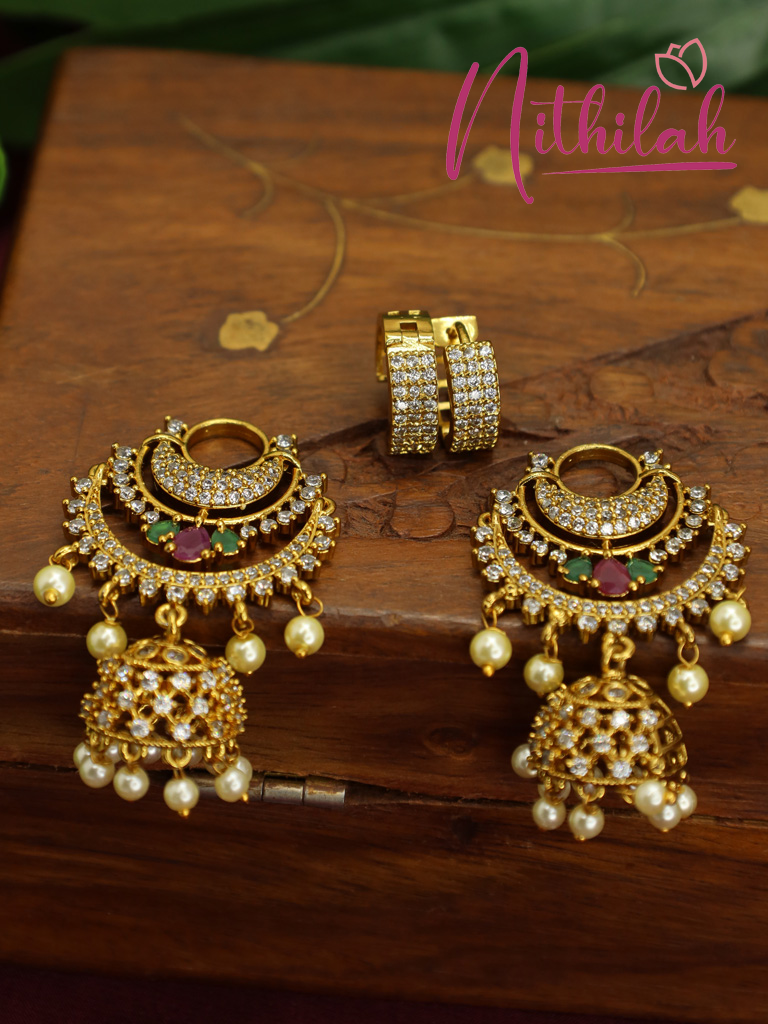 Close-up of an AD Chandbali earring showing sparkling stones, pink and green accents, and pearl embellishments.