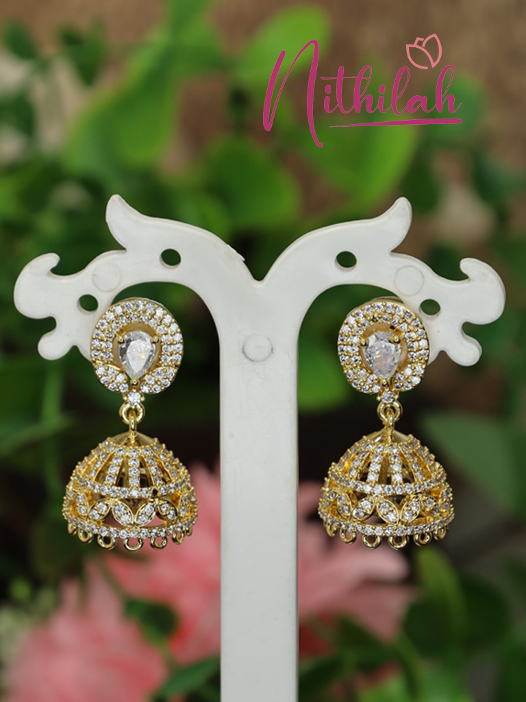 Gold-plated American Diamond jhumka earrings with teardrop-shaped stone studs and sparkling dome-shaped drops, close-up view.
Copy filenameCopy alt text