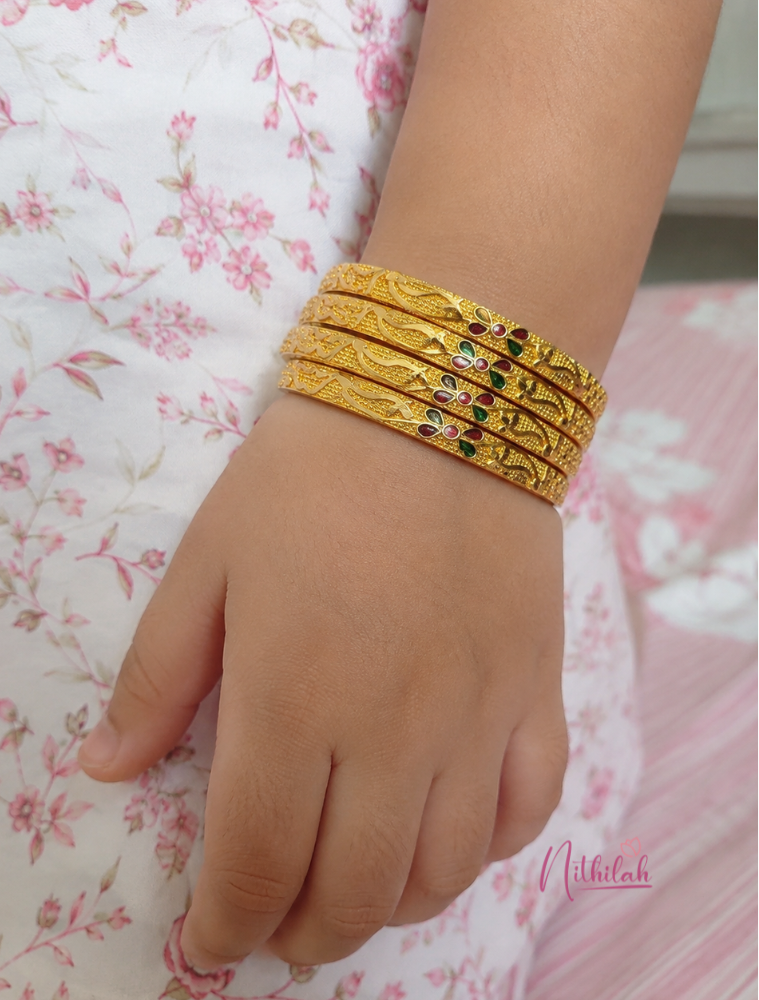 Girl wearing Premium gold look floral bangles set with traditional gold plated finish, lightweight kids jewellery for weddings and festivals.