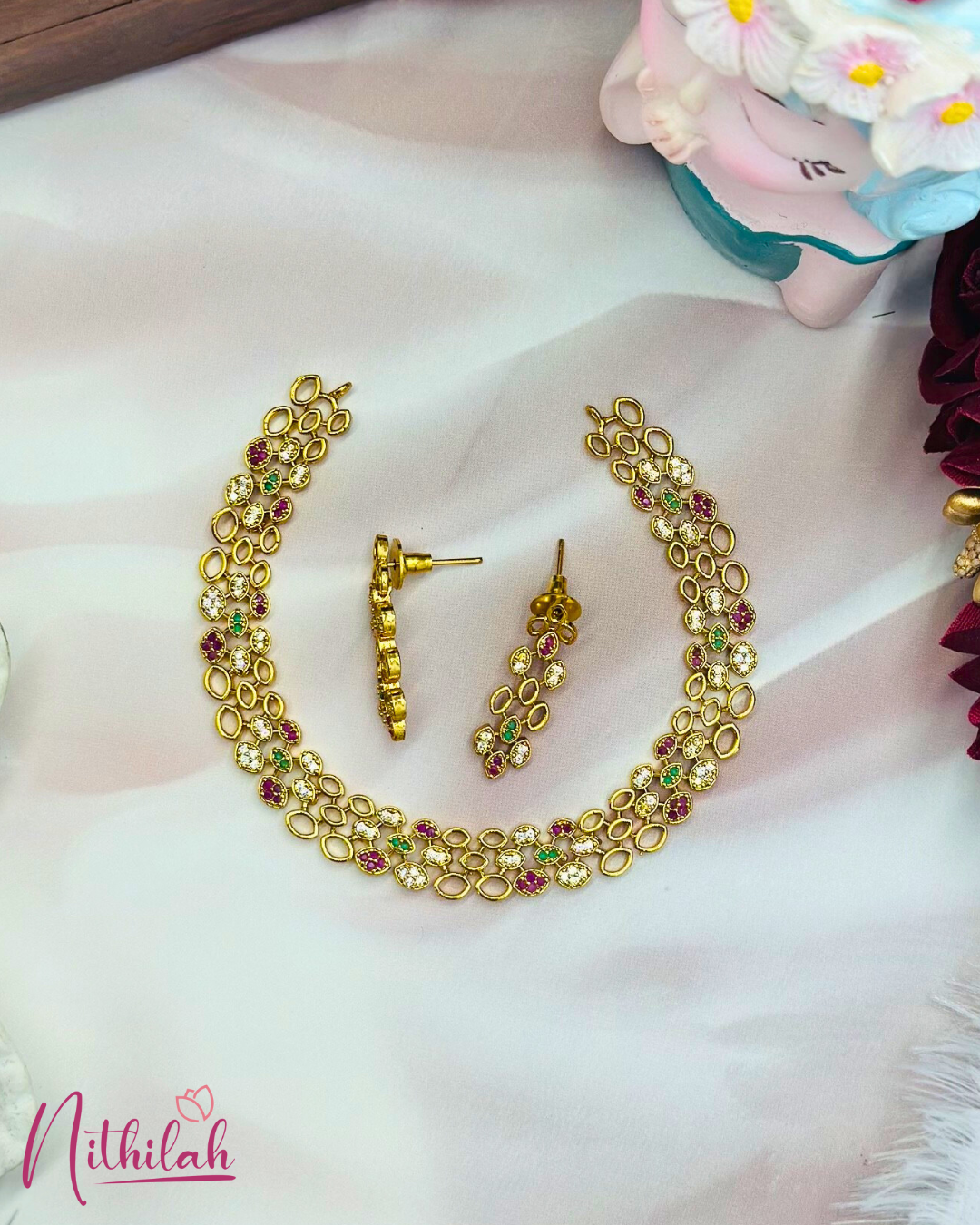 Gold-plated multicolour CZ oval-link necklace and matching earrings laid flat on a light background