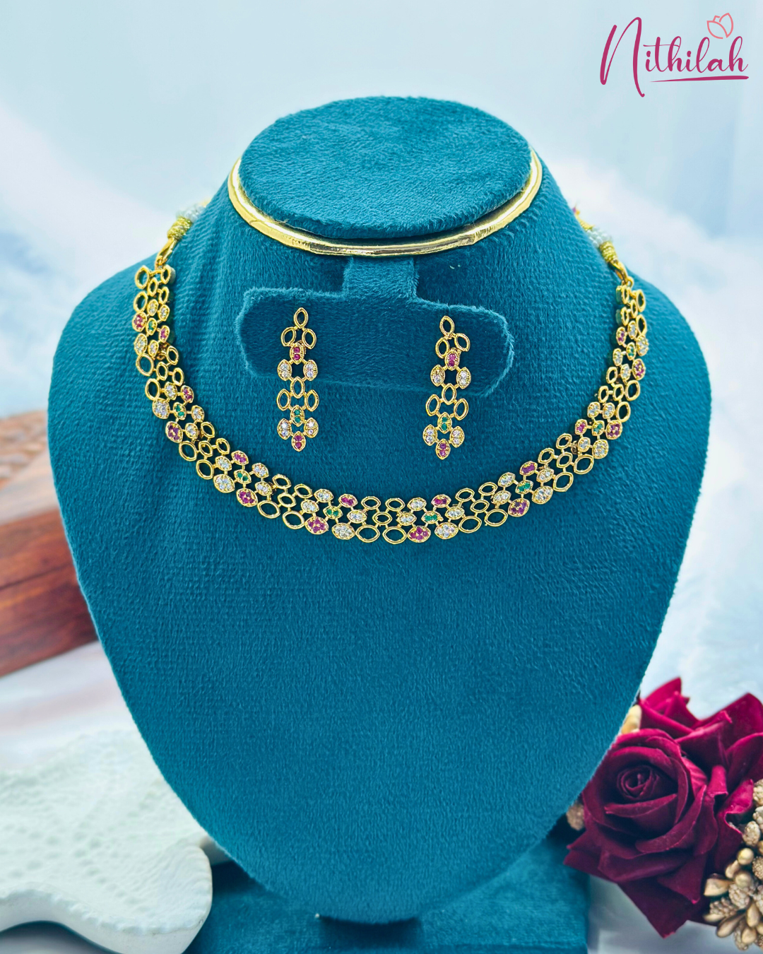 Gold-plated multicolour CZ oval-link necklace and matching drop earrings on a teal display