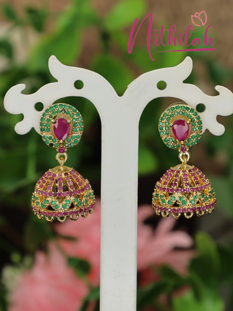 Pair of gold-plated pink and green American Diamond jhumka earrings with pink teardrop centre stones and traditional dome-shaped drops displayed on a stand.
