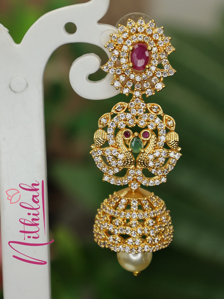 Gold-polished peacock jhumka earring with pink, green and clear stones and a pearl-like drop