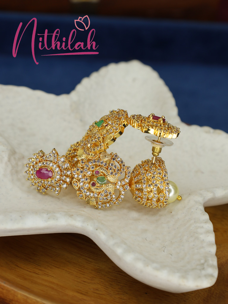 Gold-polished peacock jhumka earrings showing the side detail and push-back fastening
