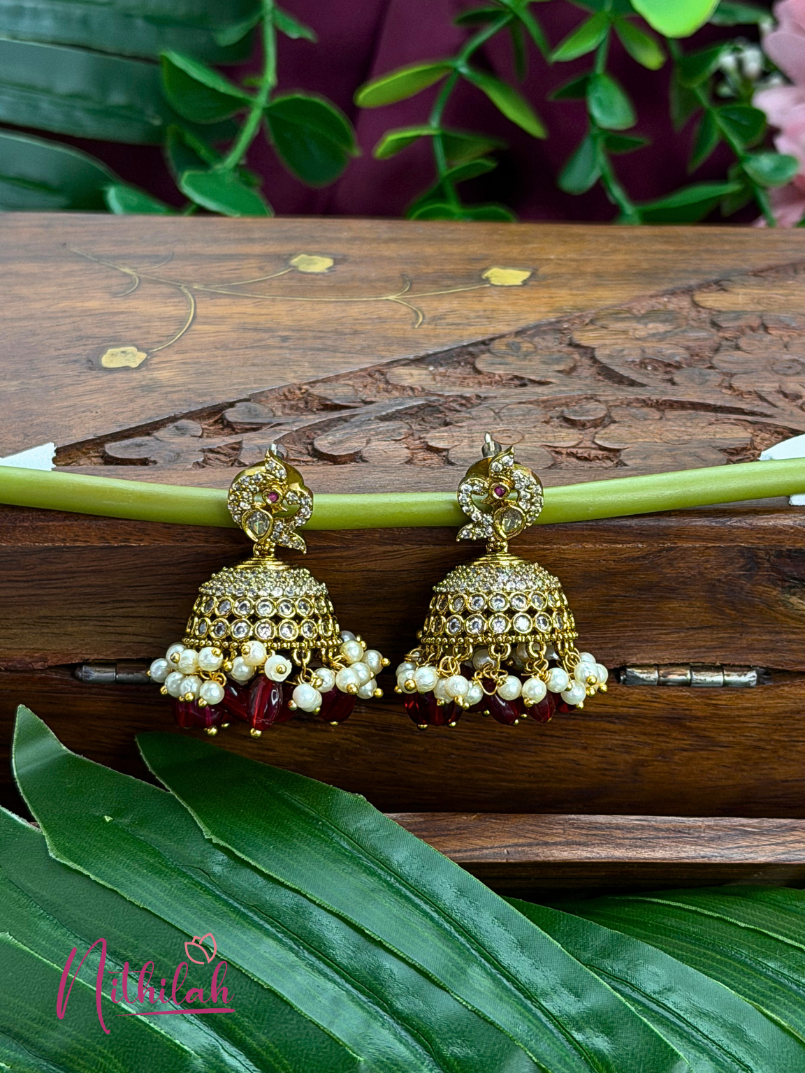 Gold tone CZ red bead and pearl jhumka earrings with traditional detailing
