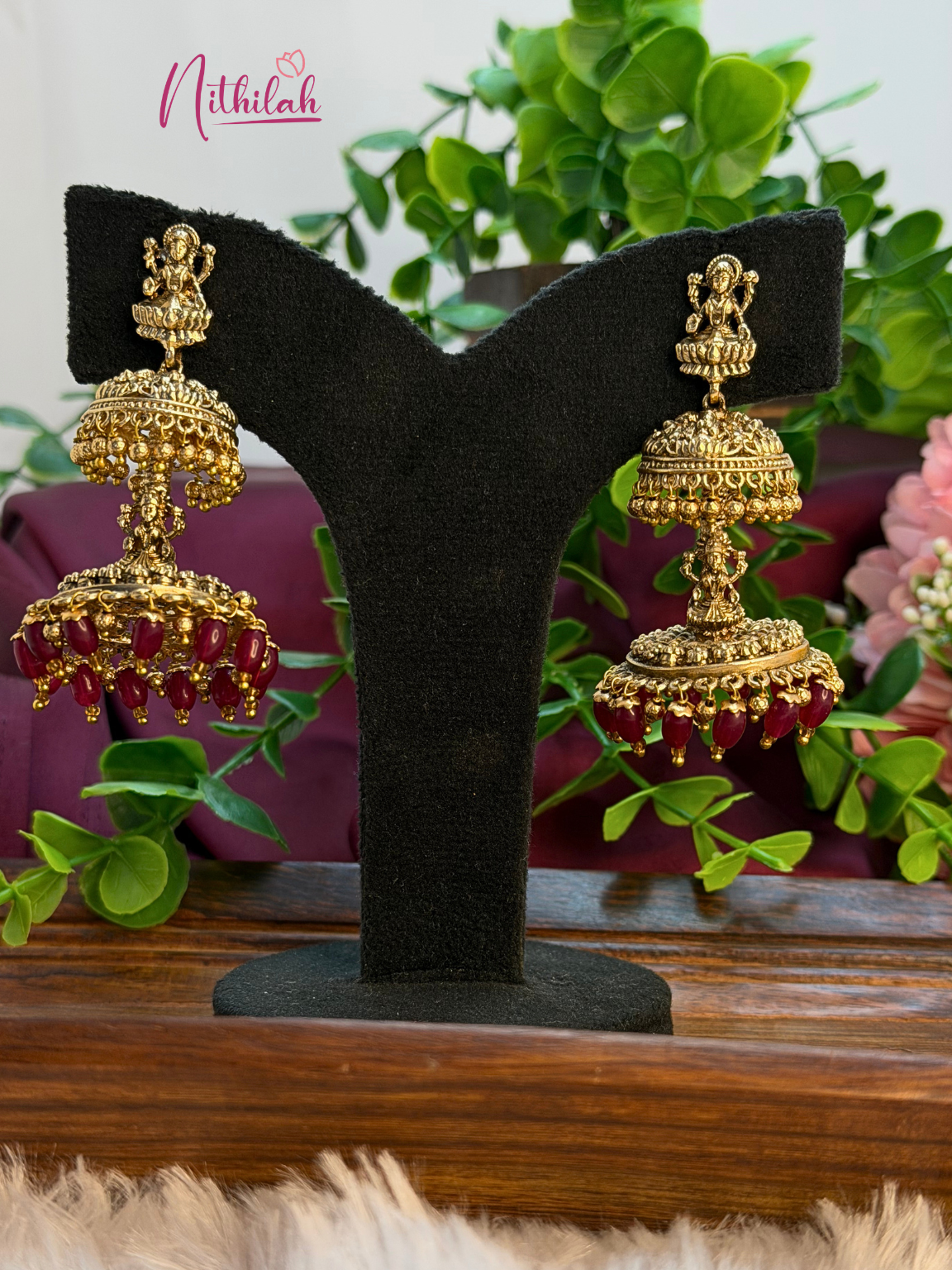 Pair of traditional gold tone Lakshmi jhumka earrings with red bead drops
