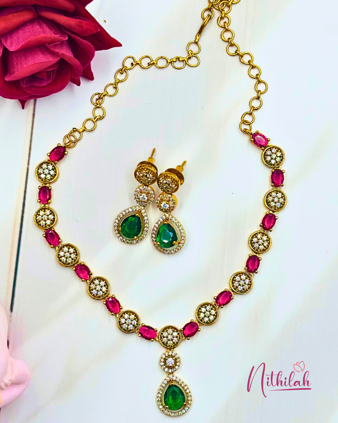 Detail of pink stones, round CZ accents and green teardrop pendant with matching earrings