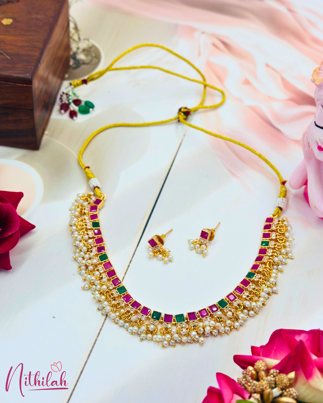 Full gold-plated ruby-pink and green necklace set laid flat, showing pearl drops, matching earrings and adjustable thread