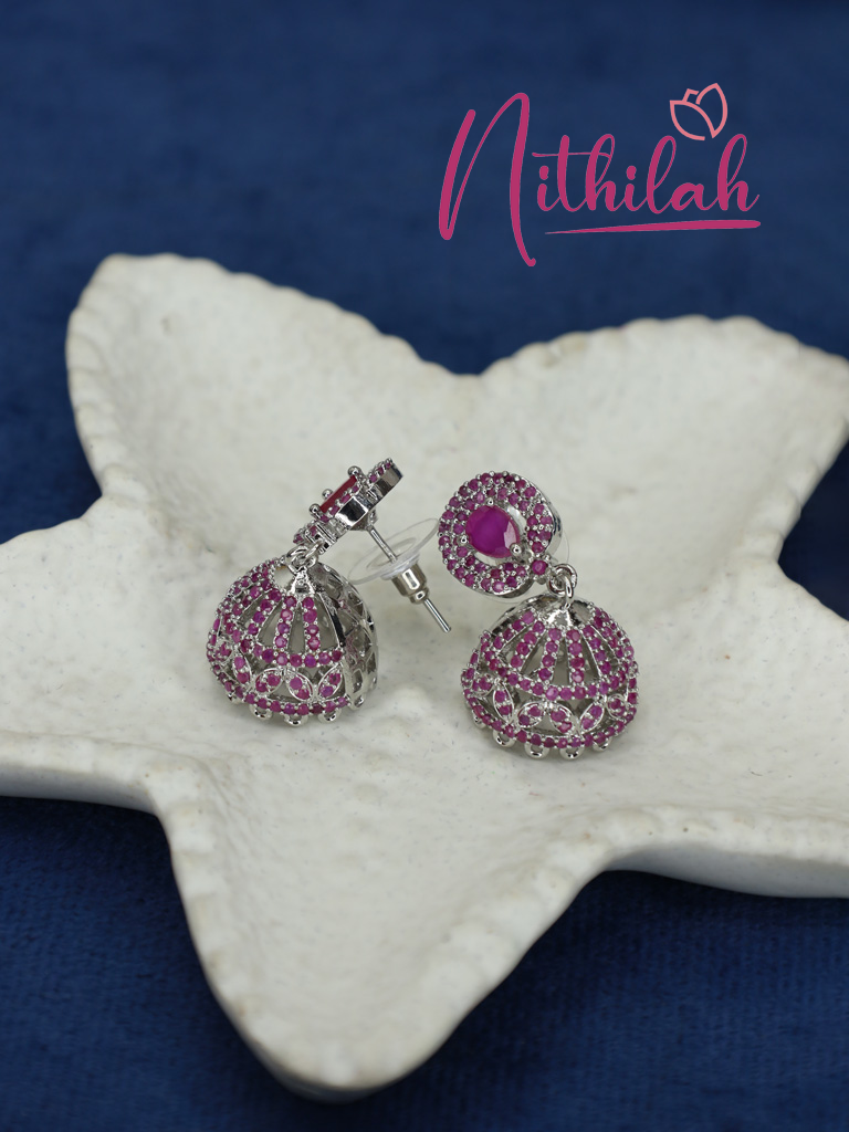 Close-up of pink AD jhumka earrings showing the teardrop centre stones, intricate dome detailing, silver-tone finish, and earring posts.