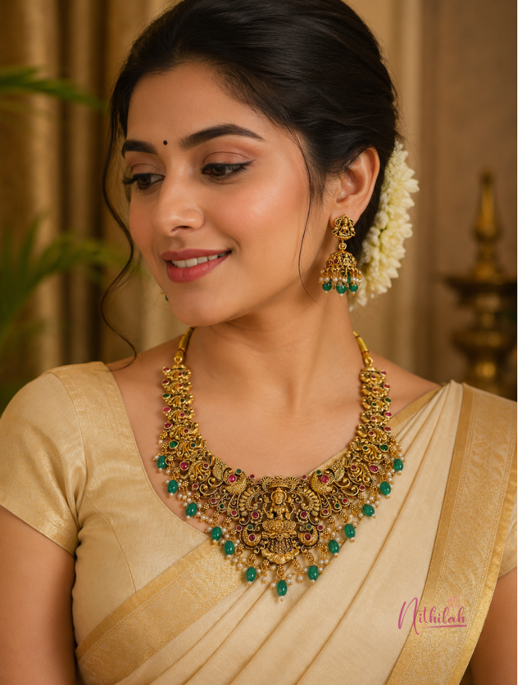 South Indian model wearing Antique Lakshmi Temple necklace with green bead drops and matching traditional jhumka earrings.